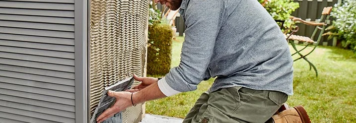 Person verlegt Steinplatten an Gartenhaus